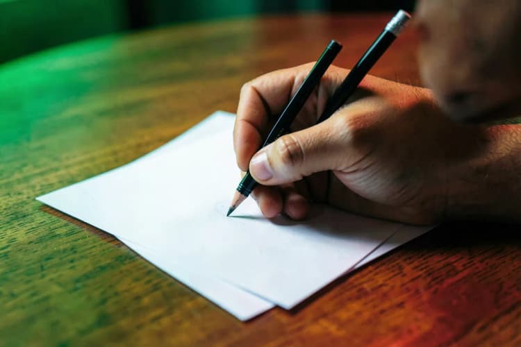 Mão desenhando em um papel com um modelo de proposta comercial.
